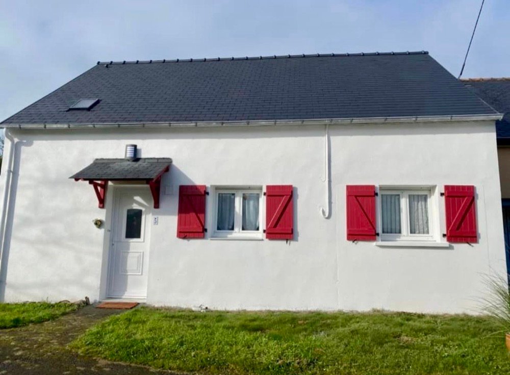 Maison après peinture de la façade et traitement de la toiture à l'hydrofuge coloré, volets rouges